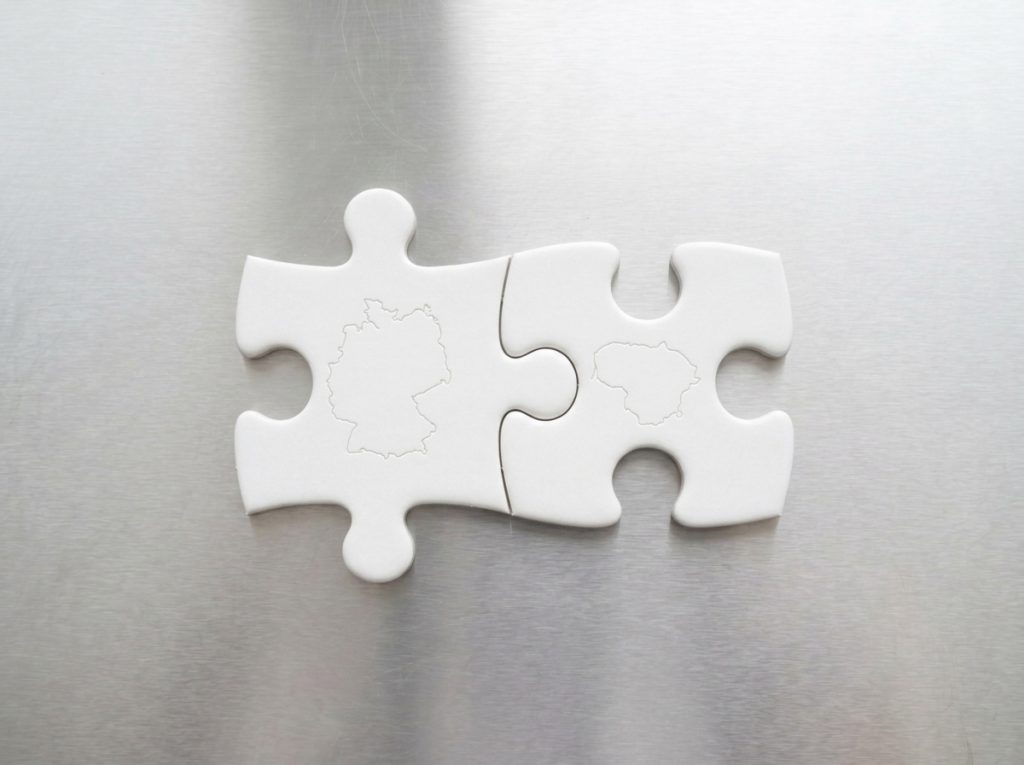 Lithuanian and German market partnership represented through connected puzzle pieces, illustrating seamless EU food supplement manufacturing and distribution by Valentis.